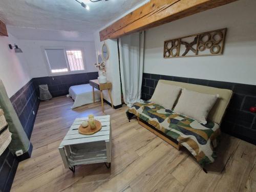 un salon avec un lit et une table dans l'établissement Charmante maison de village au calme - Animaux admis - FR-1-100-349, à Cavalaire-sur-Mer