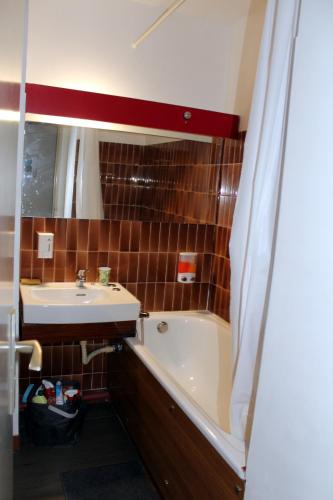 une salle de bain avec un lavabo, une baignoire et un miroir dans l'établissement Studio 0233, Port Camargue, Piscine, WiFi, Parking, 2 personnes, au Grau-du-Roi