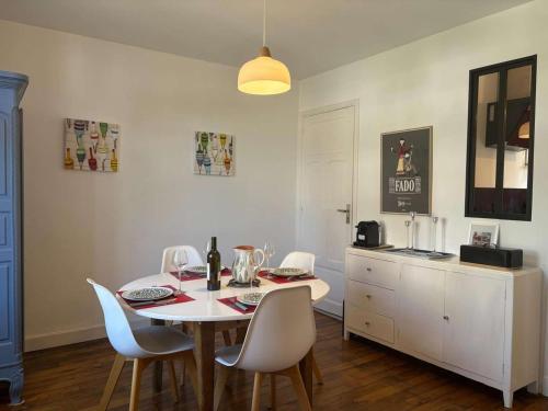 une salle à manger avec une table et des chaises blanches dans l'établissement Maison de charme à Perros-Guirec, proche plage - FR-1-542-69, à Perros-Guirec