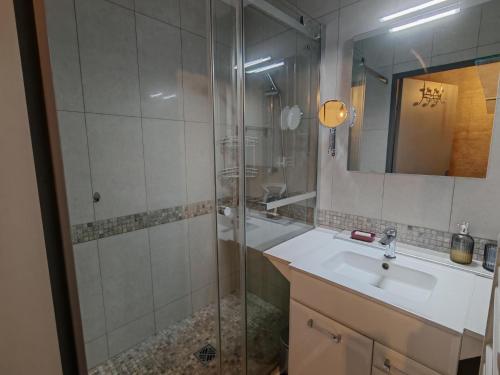 une salle de bain avec une douche, un lavabo et un miroir dans l'établissement Appartement moderne 2 chambres, proche plage et parking privatif - FR-1-732-104, à Argelès-sur-Mer