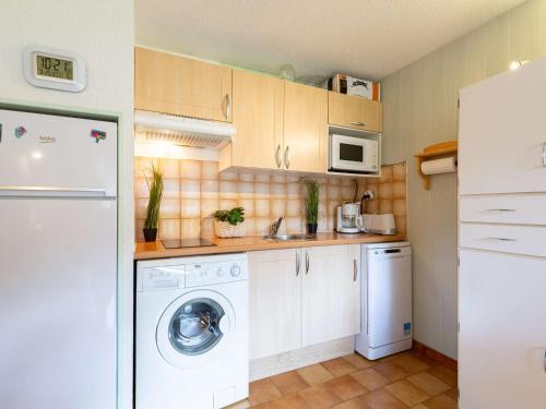 une cuisine avec un lave-linge et un micro-ondes dans l'établissement Appartement calme près du centre Saint-Lary, 700m du téléphérique, 5 pers. max - FR-1-296-516, à Saint-Lary-Soulan