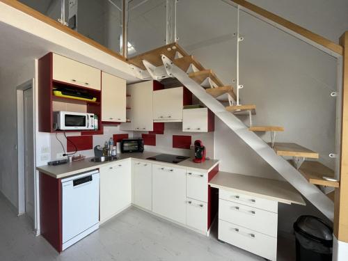 une cuisine avec des placards blancs et un escalier dans l'établissement T2 Mezzanine, 5 Pers, Face Océan à Vieux-Boucau - FR-1-379-180, à Vieux-Boucau-les-Bains