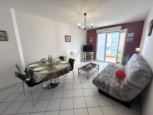 un salon avec une table et un canapé dans l'établissement Appartement lumineux 2 pièces, terrasse au sud, parking privé à Fréjus - FR-1-226A-203, à Fréjus