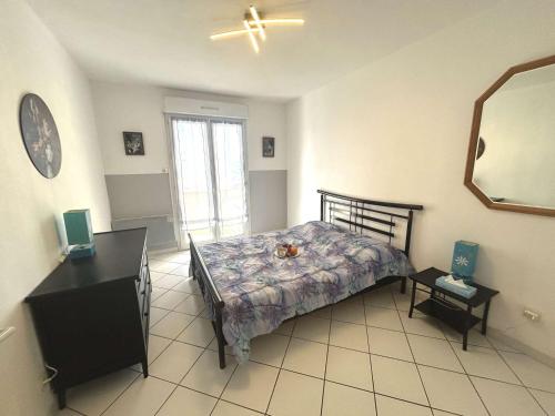 une chambre avec un lit, une commode et un miroir dans l'établissement Appartement lumineux 2 pièces, terrasse au sud, parking privé à Fréjus - FR-1-226A-203, à Fréjus