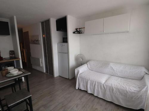 un petit salon avec un lit et une table dans l'établissement Studio Cabine avec Terrasse, Piscine et Parking sécurisé - FR-1-307-282, au Grau-du-Roi