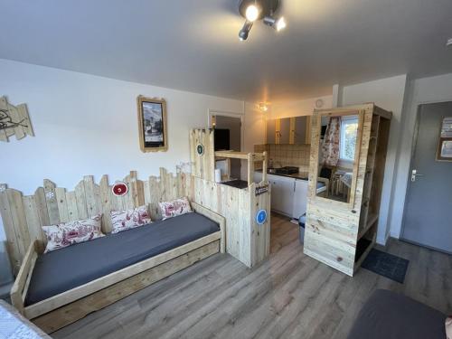 Cette chambre comprend un lit avec des cloisons en bois et une cuisine. dans l'établissement Coquet T2 au coeur du Lioran - FR-1-787-120, à Laveissière