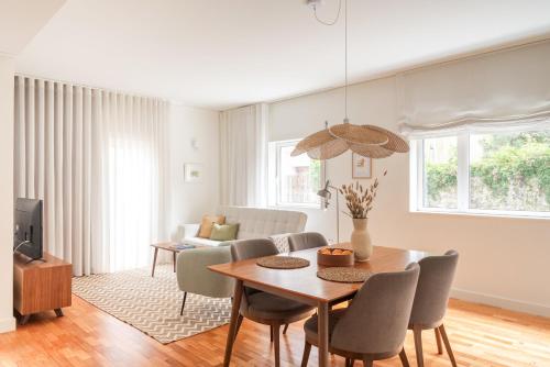 a living room with a table and chairs and a couch at Bombarda Homes in Porto
