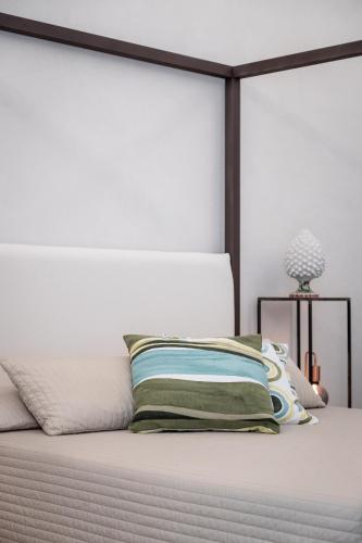 a bed with a white headboard and a pillow at Bed and Breakfast Welcome in Noto