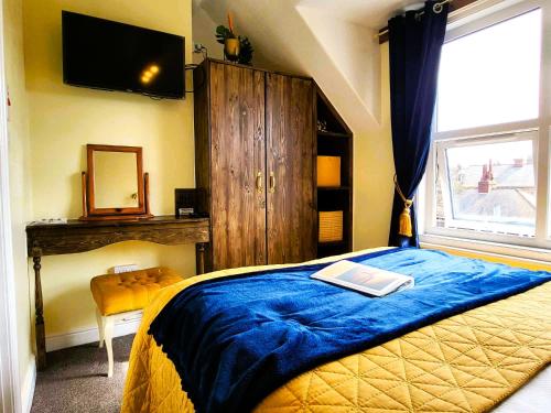 a bedroom with a bed with a book on it at The Kensington in Scarborough