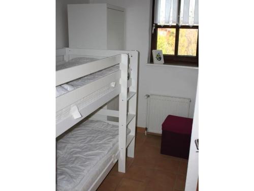 a white bunk bed in a room with a window at Thölkes Haus am Meer in Butjadingen