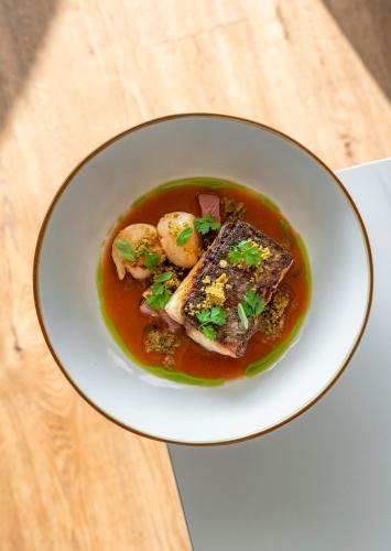 a bowl of soup with shrimp and meat on a table at Bes Hotel Terme a Palazzago in Palazzago