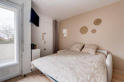 une chambre blanche avec un lit et une fenêtre dans l'établissement Le Gabby, à Toulouse