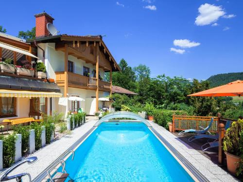 una piscina frente a una casa en Ferienwohnungen Scheifler en Berchtesgaden