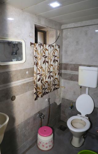 Un baño pequeño con inodoro y lavabo. en Hotel Sairaj INN, en Dombivli