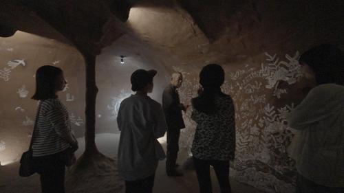 a group of people looking at a painting on a wall at Private Chill Base たまて 三豊市荘内半島の古民家宿 一棟貸しも可 in Mitoyo