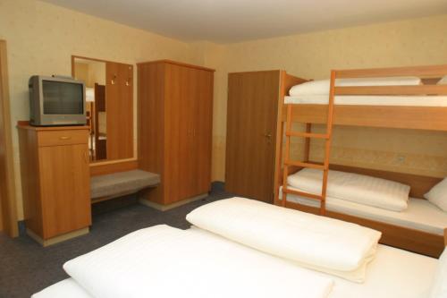 a small room with bunk beds and a television at Hotel und Gasthof Ritter St. Georg in Erlangen