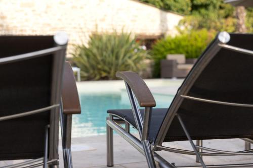 two chairs sitting in front of a swimming pool at Le Moulin de Beaunette in Grane