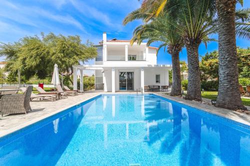a swimming pool in front of a villa at Albero Villa Polychrono in Polychrono