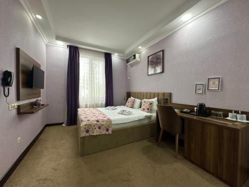 a hotel room with a bed and a desk with a computer at Hotel Park in Batumi