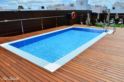 a swimming pool on the deck of a building at Hotel y Apartamentos Conilsol in Conil de la Frontera
