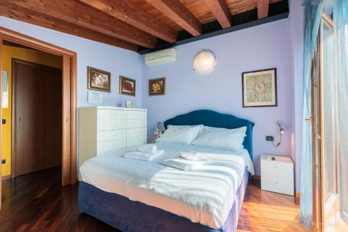 a bedroom with a bed with blue walls and wooden floors at Art Gallery Living & Working in Stezzano