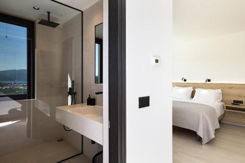 a bedroom with a bed and a sink and a mirror at Villa Kafkales Maleme - Heated Pool in Maleme