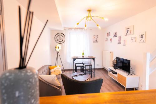 un salon avec un canapé et une table dans l'établissement Découvrez le charme du duplex pour 2 personnes, à Châlons-en-Champagne