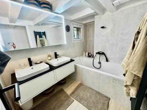 une salle de bain avec deux lavabos, une baignoire et un miroir dans l'établissement Magnifique villa avec piscine village à pied, à Éguilles