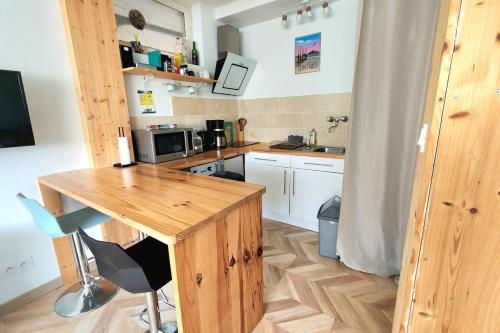 Il comprend une cuisine avec une table en bois et un bureau. dans l'établissement L'ambraga 1 bedroom - near beach, à Saint-Malo