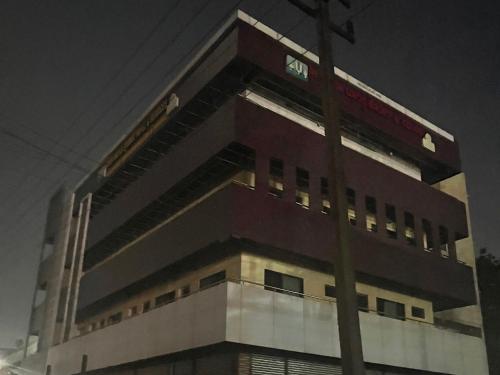 a building with a sign on the side of it at Townhouse Dharawada Taluku Formerly Shri Balaji Hotel in Mugad