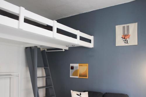 une chambre avec un lit superposé avec une échelle dans l'établissement Beautiful mezzanine studio in the city center, à Saint-Ouen