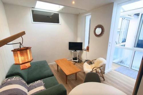 un salon avec un canapé vert et une table dans l'établissement Lovely flat close to the beach, à Saint-Malo