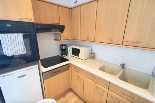 une petite cuisine avec un micro-ondes et un évier dans l'établissement Lovely flat close to the beach, à Saint-Malo