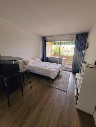 - une chambre avec un lit, un bureau et un piano dans l'établissement Studio 0237 Port Camargue, Piscine, Climatisation, 2 personnes, au Grau-du-Roi