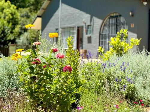 a garden with flowers in front of a house at Fiddler's Green in Magoebaskloof