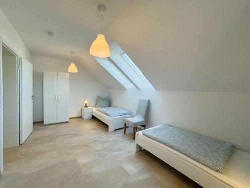 a bedroom with a bed and a couch and a skylight at Wangermeer Perle II in Wangerland