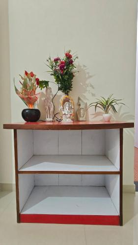 a wooden shelf with flowers and other items on it at Chandrajyoti Villa 5 Ground floor Villa in Nagpur