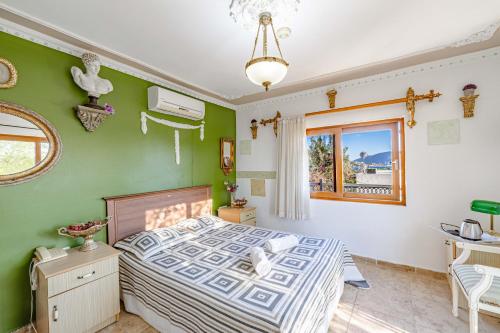 a bedroom with a bed with green walls and a window at Casa Roma Boutique Hotel in Bodrum City