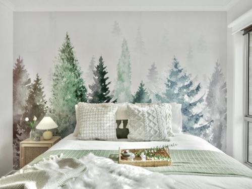 a bedroom with a bed with christmas trees on the wall at Modern holiday home in Hobart - Stunning Mountain & Water views in Rosetta