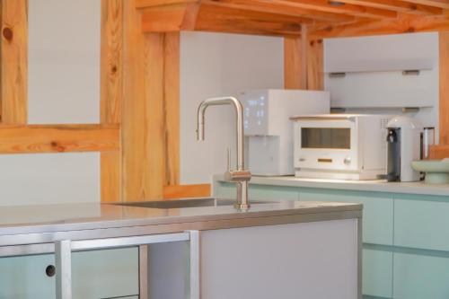 a kitchen with a sink and a microwave at Hanok stay Jungwooga in Gyeongju