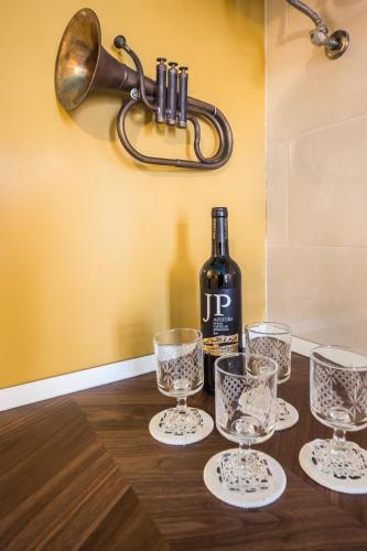 a bottle of wine and glasses on a table at YBaixa - Boutique Apartments in Setúbal