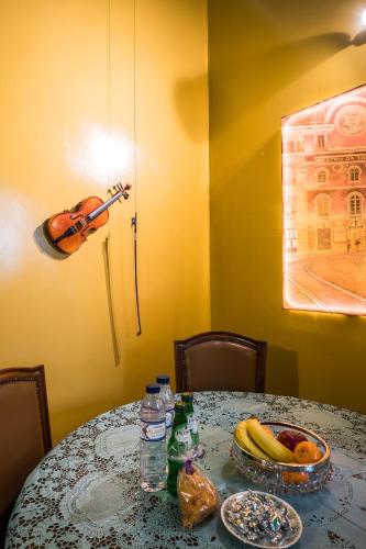 a table with a violin and a bowl of fruit at YBaixa - Boutique Apartments in Setúbal