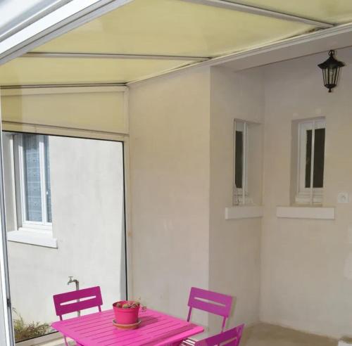 une table rose et deux chaises sur la terrasse dans l'établissement Les vignes de la Bouvinerie, à Montlouis-sur-Loire