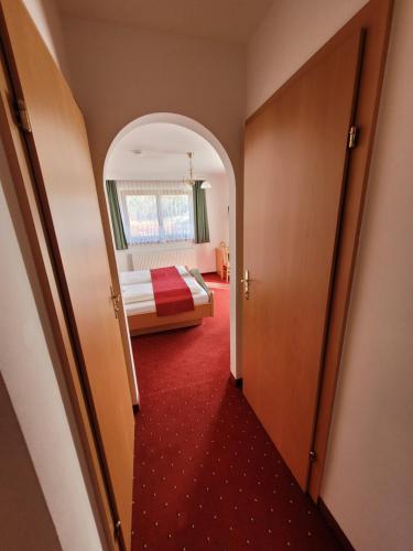 a hotel room with a bed and a red carpet at Komfort Appartement Royal Windberger in Schladming