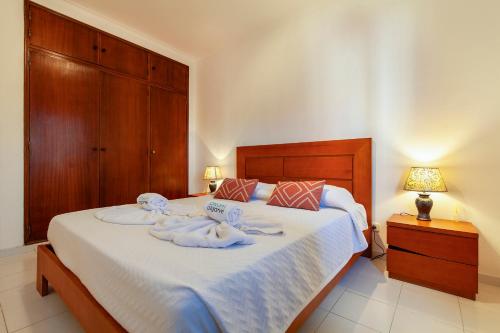 a bedroom with a bed with towels on it at Rio a Vista Praia da Rocha Flat in Portimão