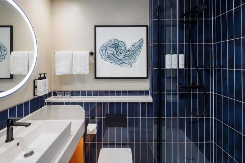 a bathroom with a shower and a sink at voco Southampton by IHG in Southampton
