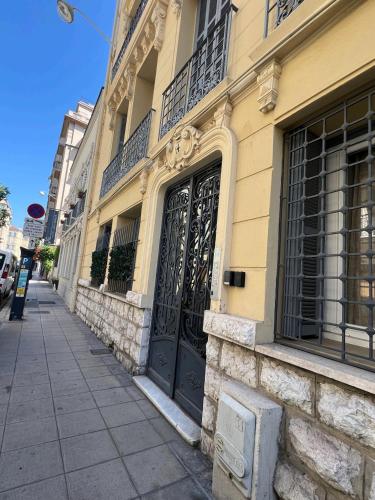 un bâtiment avec une porte noire dans une rue dans l'établissement Coquette studio YourHostelper, à Nice