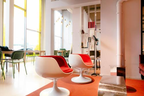 a room with two white chairs and a table at The Social Hub The Hague in The Hague