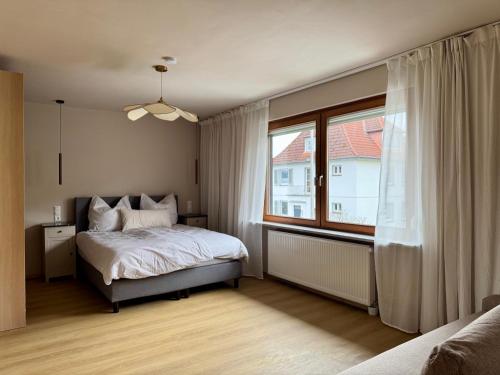 a bedroom with a bed and a large window at Ferienwohnung Flusshochdrei in Hannoversch Münden