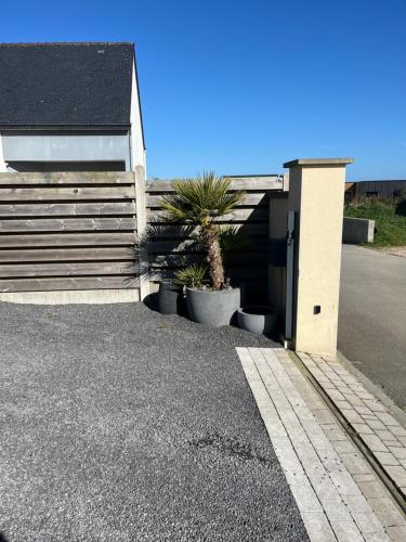 a house with two potted plants next to a building at Maison bonheur in Plouénan